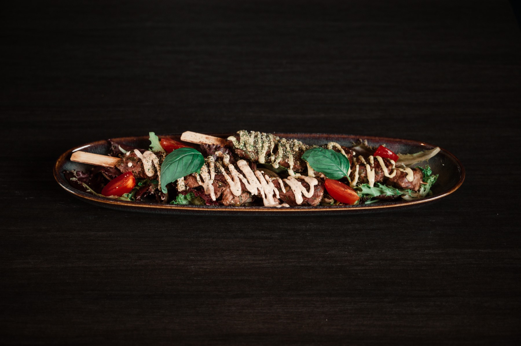 Brochettes de viande sur assiette longue